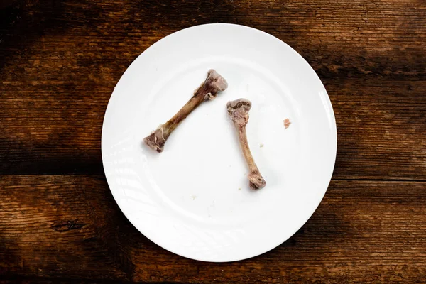 Hühnerknochen Auf Einem Weißen Teller Dunkler Holzhintergrund Ende Der Mahlzeit — Stockfoto
