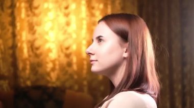 Genç kadın portresi etrafa rüya gibi bakıyor. Kahverengi saçlı kadın. Altın arka plan. Düşünceler, yansımalar.