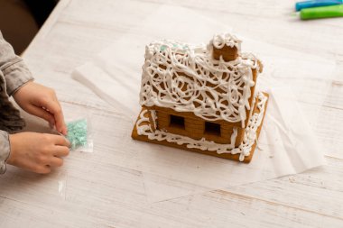 Çocuk zencefilli kurabiye evi yapıyor. Tatil hazırlığı, yaratıcı aktivite.