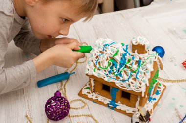 Çocuk zencefilli kurabiye evi yapıyor. Tatil hazırlığı, yaratıcı aktivite.