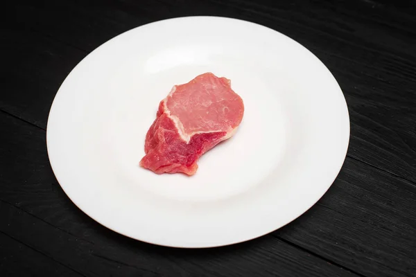 Кусок Свиной Отбивной Белой Тарелке Черном Деревянном Фоне Жирное Мясо — стоковое фото