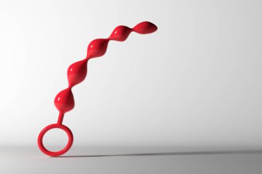 Taşaklı anal stimülatör. Kırmızı vibratör beyaz arka planda havaya kalkıyor. Seks dükkanı, samimi eğlence konsepti. Mesaj için yer. 3 Boyutlu Hazırlama.