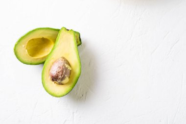 Beyaz arka planda dilimlenmiş avokado. Minimalizm. Sağlıklı, vejetaryen yemekleri..