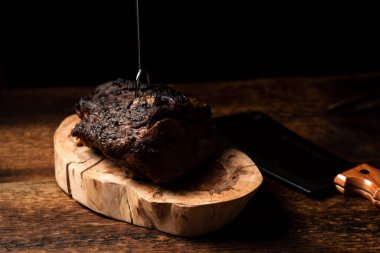 Ahşap tezgahta pişmiş bir parça et. Baharatlı fırında pişirilmiş domuz ya da sığır eti..