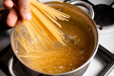 Spagettiyi bir tencerede kaynayan suya daldır. Makarna pişirme.