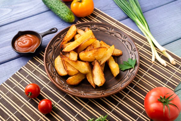 Masadaki tabakta farklı sebzelerle birlikte büyük parçalar halinde kızarmış patates..