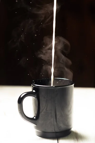 ミルクは熱いコーヒーのカップに注ぐ — ストック写真