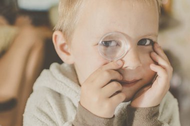 Küçük bir çocuk büyütece bakıyor..