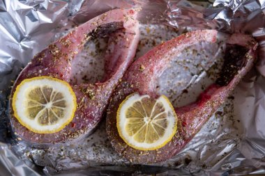 Limonlu çiğ sazan bifteği. Folyonun üzerine baharatlar serpiştirilmiş. Yemek hazırlığı.