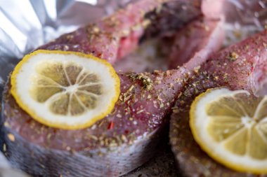 Limonlu çiğ sazan bifteği. Folyonun üzerine baharatlar serpiştirilmiş. Yemek hazırlığı.