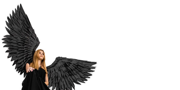 Black Angel. Young girl with black angel wings against white background. Banner. Place for text.