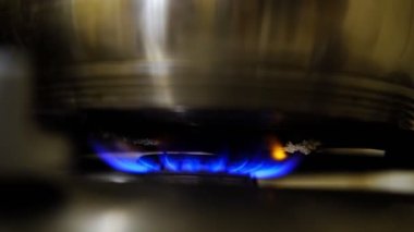 Bir tencerenin altında yanan bir gaz ocağı. Yemek pişirmek..
