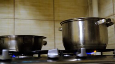 Gaz ocağında bir tava ve bir tencere. Buhar geliyor. Yemek pişirme.