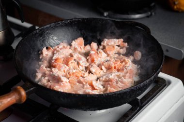 Parçalanmış somon tavada kızartılır.