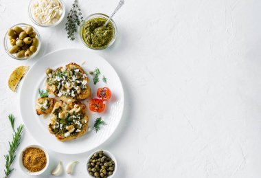 Baharatlı karnabahar bifteği, chimichurri sosu, badem gevreği, zeytin, kızarmış vişneli domates ve beyaz tabakta kapari. Vejetaryen yemeği. Beyaz arka plan. Kopyalama alanı.