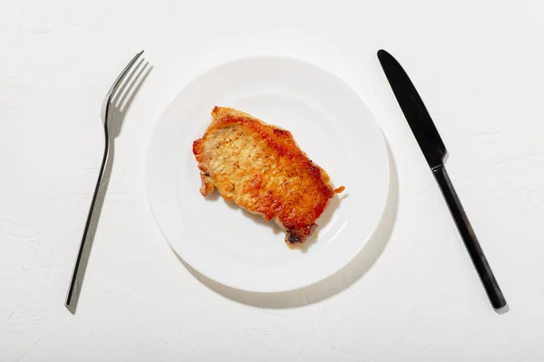 Pedaço Carne Frita Num Prato Branco Faca Preta Garfo Comida — Fotografia de Stock