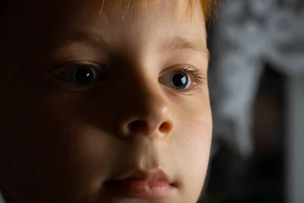 一个红头发的小男孩在一间黑暗的房间里的画像 — 图库照片