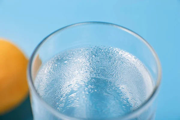 青い背景にレモンと純粋な冷たい水のガラス — ストック写真