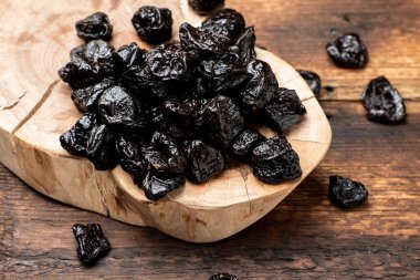 Ahşap arka planda kurumuş kuru erik. Kuru meyveler.