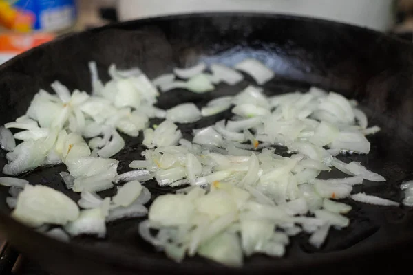 Fried onions in a pan. Preparation for cooking dishes with onions.