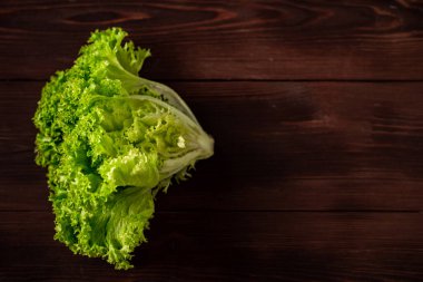 Ahşap arka planda yeşil marul salatası. Vejetaryenlik konsepti, bitki gıdası. Metin için yer.