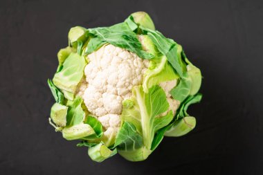 Karanlık bir arka planda bütün karnabahar. Vejetaryen yemeği..