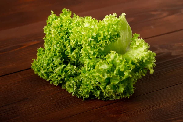 在木制背景上的绿色生菜沙拉 素食主义概念 植物食物 — 图库照片