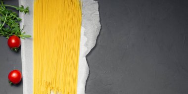 Gri arka planda pişmemiş sarı spagetti. Pankart, metin için yer.