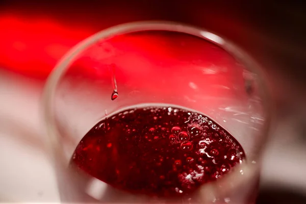 Red carbonated drink, champagne in a glass close-up.