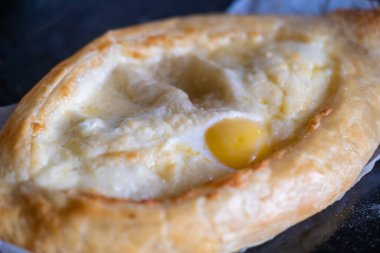 Pişirme tepsisinde Adjarian Khachapuri. Geleneksel Gürcü yemeği peynirli ve tavuklu yumurta..