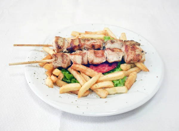 Souvlaki griego con cebolla y papas fritas —  Fotos de Stock