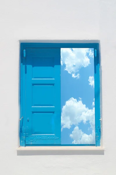 Tradicional ventana griega contra una pared blanca y el cielo nublado — Foto de Stock