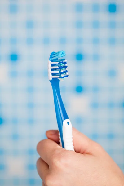 Mão segurando escova de dentes — Fotografia de Stock