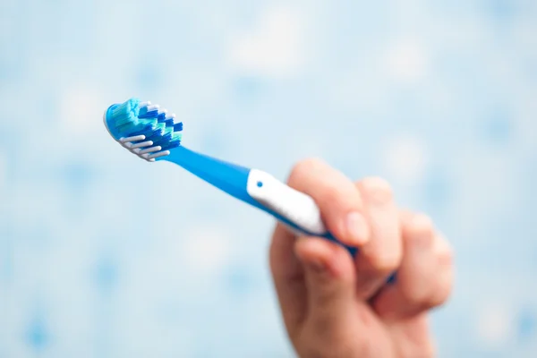 Mão segurando escova de dentes — Fotografia de Stock