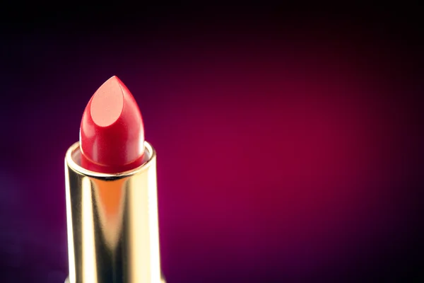 Lipstick on purple background — Stock Photo, Image