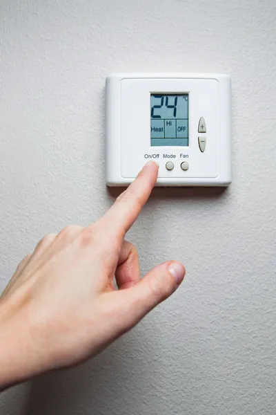 hand turning on digital climate control