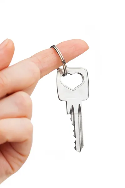 Hand som håller nyckeln isolerad på vit — Stockfoto