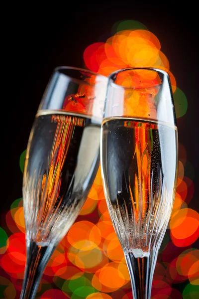 Champagne glasses against christmas tree bokeh lights — Stock Photo, Image