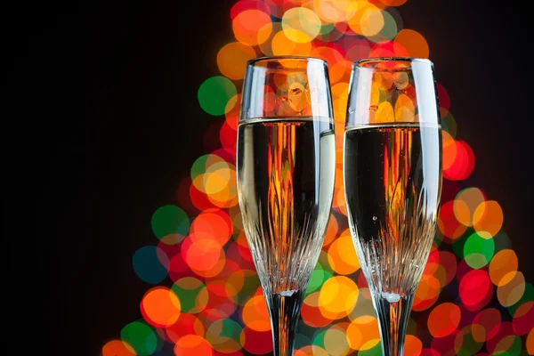 Copas de champán contra las luces bokeh árbol de Navidad —  Fotos de Stock