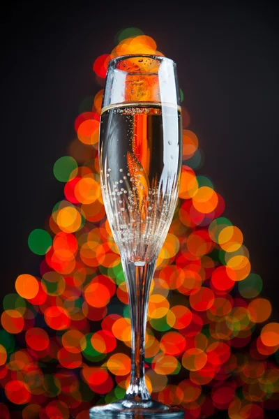 Champagnerglas gegen Weihnachtsbaum-Bokeh — Stockfoto