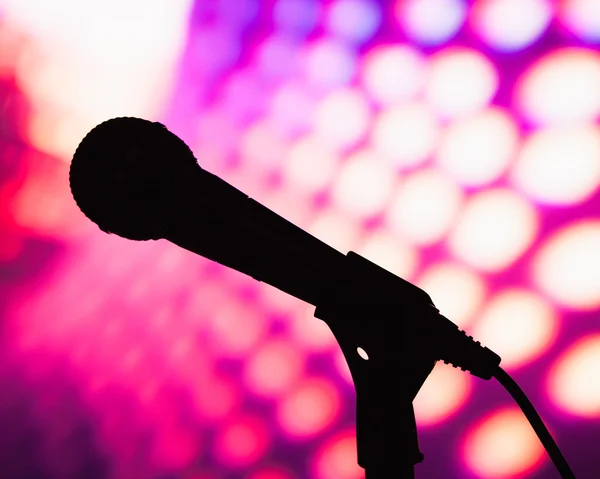 Силуэт микрофона на фиолетовом диско фоне — стоковое фото
