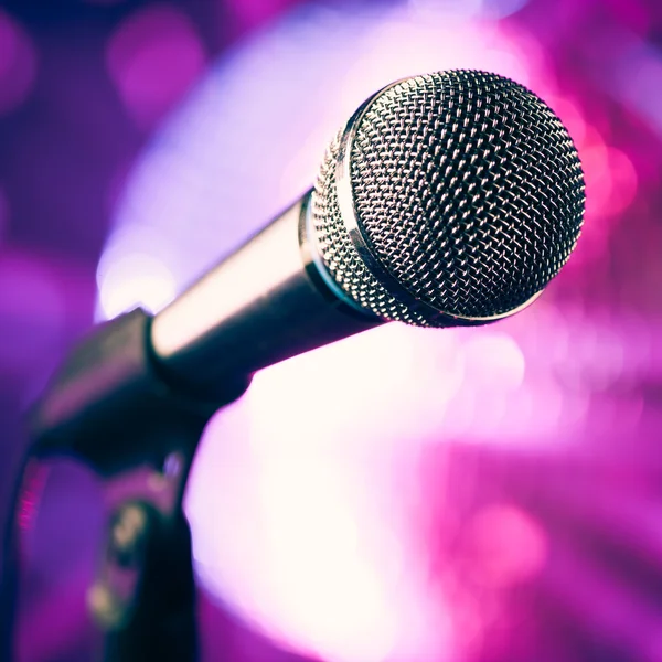 Microfoon tegen paarse disco achtergrond — Stockfoto