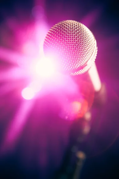 Microphone on stage with purple shiny glare — Stock Photo, Image