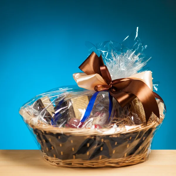 Geschenk im Korb vor blauem Hintergrund — Stockfoto