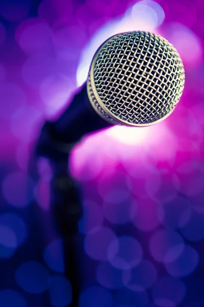 Microfone contra raios roxos fundo — Fotografia de Stock
