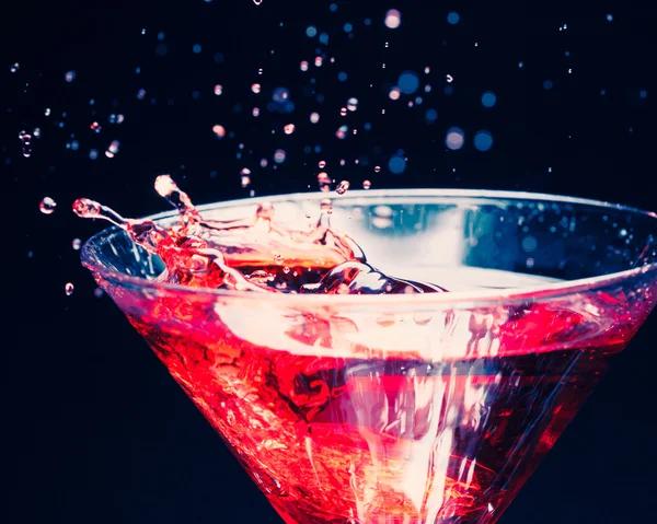 Red splashing cocktail on black — Stock Photo, Image