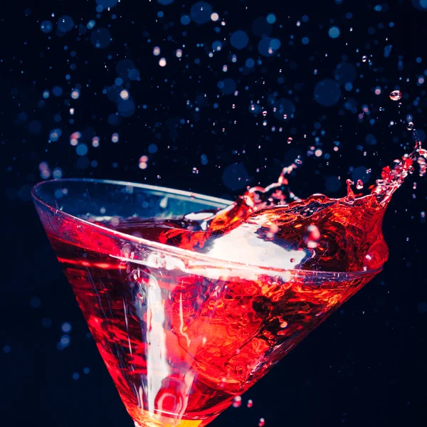 Red splashing cocktail on black — Stock Photo, Image