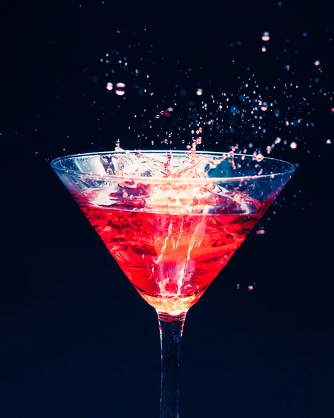 Red splashing cocktail on black — Stock Photo, Image