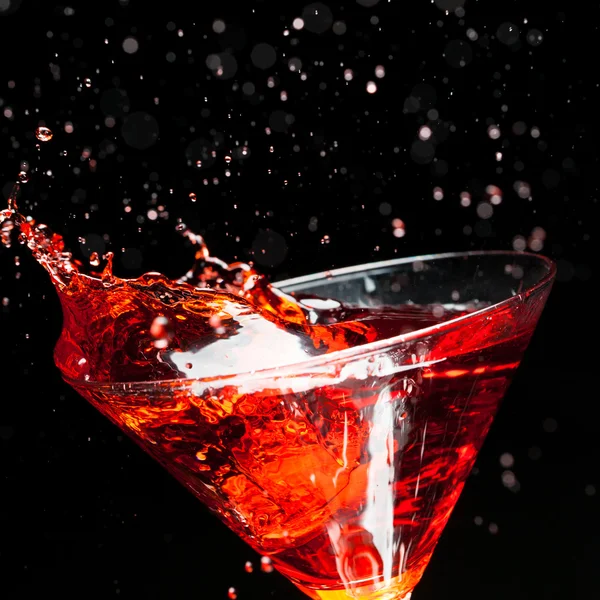 Red splashing cocktail on black — Stock Photo, Image