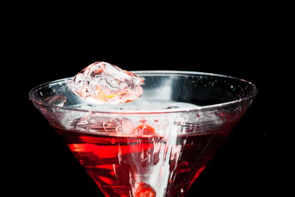 Red splashing cocktail on black — Stock Photo, Image